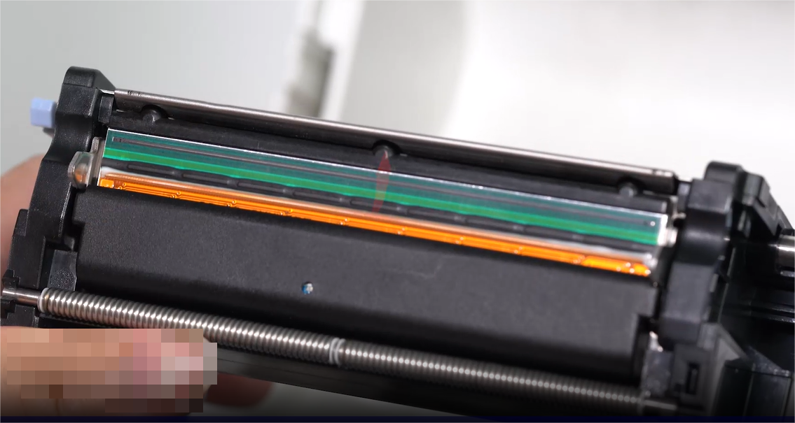 Bir close-up of a person carefully cleaning an electronic component with a swab.
